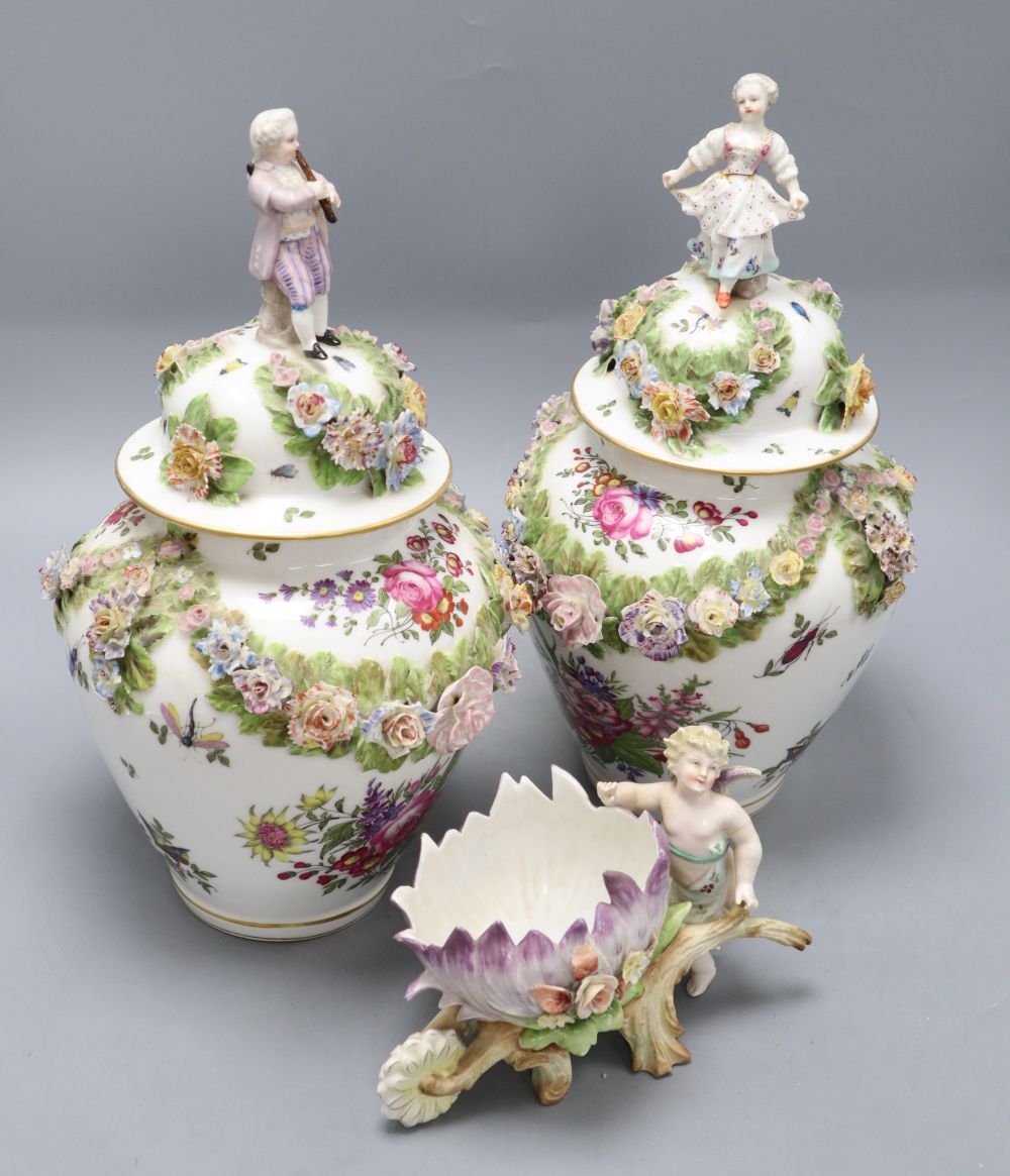 A pair of Augustus Rex floral encrusted porcelain vases and covers and a similar putti centrepiece, tallest 37cm